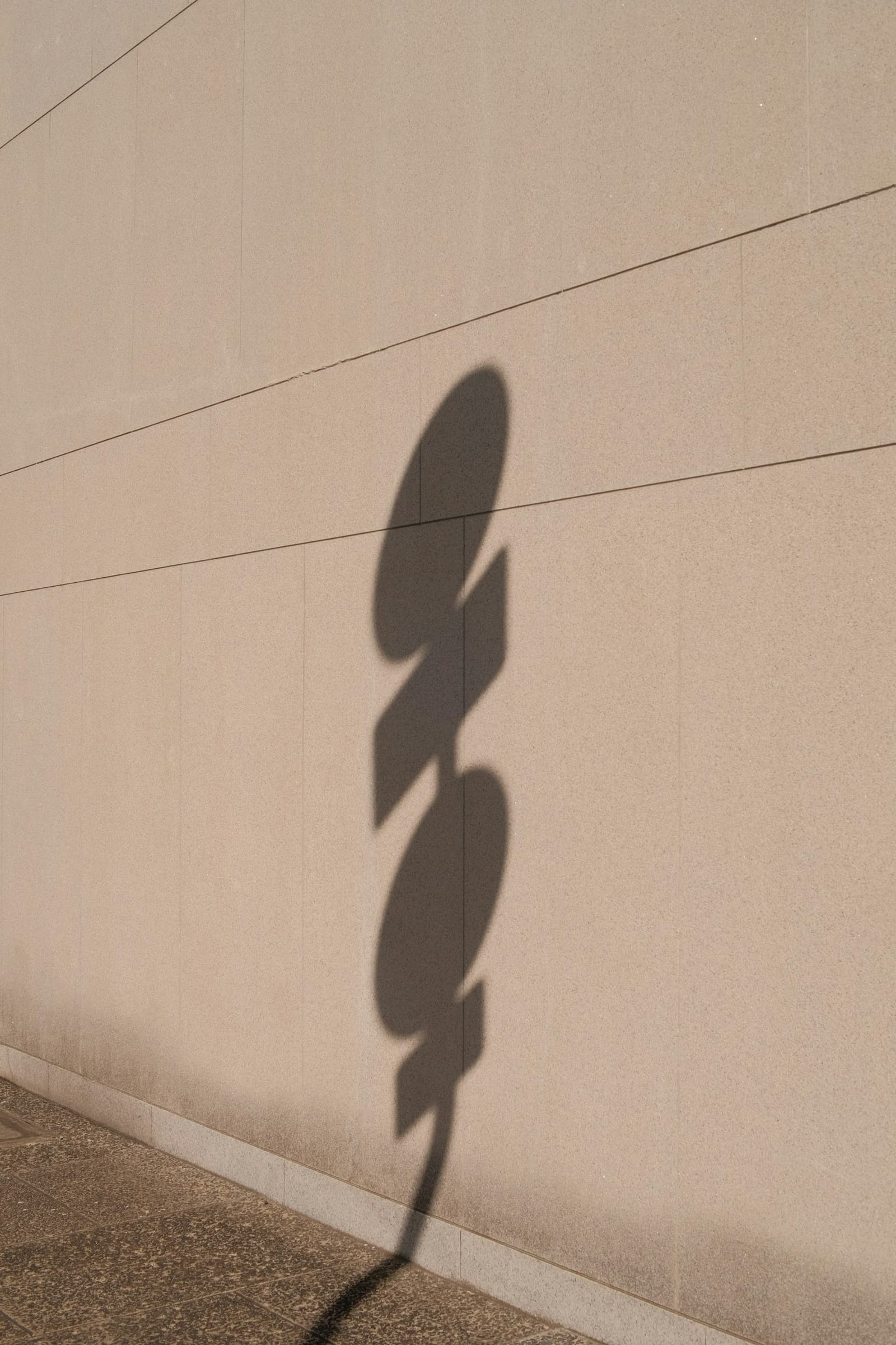 Schatten einer Skulptur auf sandfarbener Wand